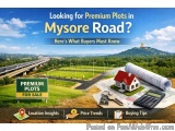 The image is an advertisement for premium plots in Mysore Road. It has a blue background with a photo of a highway and a moun...