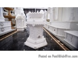 The image shows a white marble altar in a temple or shrine. The altar is in the center of the image and is made of a smooth,...