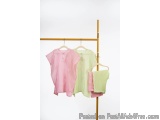The image shows a clothes rack with three clothes hanging on it. The rack is made of bamboo and has a gold finish. On the lef...