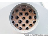 The image shows a close-up of a round, white object with a hole in the center. The object appears to be made of metal and has...