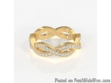 The image is of a gold ring with a twisted design. The ring appears to be made of gold and has a smooth, polished finish. The...