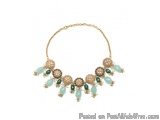 The image is of a statement necklace. The necklace is made of gold and has a gold chain. It has a pendant in the shape of a c...