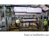 The image shows a large industrial machine inside a factory or workshop. The machine appears to be a large, industrial-lookin...