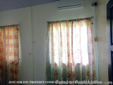 The image shows a room with two curtains hanging on the wall. The curtains are made of sheer fabric with a floral pattern in...