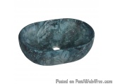 The image is of a round, oval-shaped vessel sink. The sink is made of a dark blue-green marble-like material with a glossy fi...