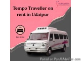 The image shows a white bus with a pink stripe on the side. The bus is parked on a road with a gray background. On the left s...