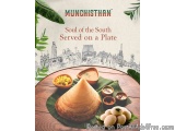 The image is an advertisement for a South Indian restaurant called Munchishthan. The background of the image is a wooden tabl...