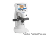 The image shows a white-colored medical device, which appears to be a microscope or a microscope stand. The device has a larg...