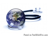 The image shows a small globe with a stethoscope attached to it. The globe is spherical in shape and appears to be made of gl...