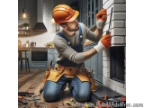 In this image, we can see a man wearing an orange hard hat and overalls, working on a brick fireplace. He is kneeling on the...