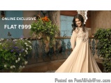 The image shows a young woman wearing a long, flowing, beige-colored dress with intricate embroidery on the neckline and slee...