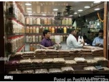 The image shows the interior of a store with a large display case filled with various types of food items. The store appears...