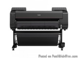 The image shows a Canon brand large format printer. The printer is black in color and has a sleek and modern design. It has a...