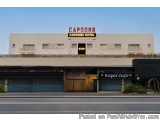 The image shows the exterior of a hotel named "Capoors Hotel". The hotel is a two-story building with a white exterior and a...