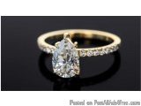 The image is a close-up of a gold ring with a pear-shaped diamond in the center. The diamond is set in a prong setting and is...