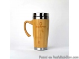 The image is of a wooden travel mug with a stainless steel lid. The mug is made of bamboo and has a handle on the left side f...