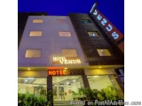 The image shows the exterior of a hotel named "Hotel Venus". The building is a modern, two-story structure with a flat roof a...