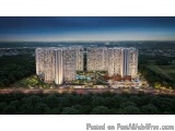 The image is an aerial view of a modern apartment complex at night. The complex is located in the middle of a vast landscape,...