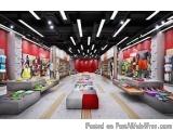 The image shows the interior of a shopping mall. The mall has a high ceiling with recessed lighting. The walls are painted in...