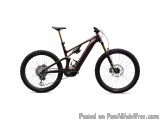 The image is of a mountain bike. The bike is a full suspension mountain bike with a maroon and gold color scheme. It has a bl...