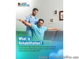 The image shows a man sitting on a couch with his arms stretched out in front of him. He is wearing a blue shirt and has a st...