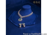 The image shows a necklace and earring set displayed on a blue velvet jewelry display stand. The necklace is a statement piec...