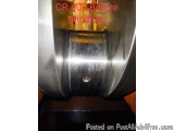 The image shows a close-up of a metal object, which appears to be a grinding wheel. The wheel is made of stainless steel and...