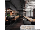 The image shows the interior of a modern restaurant or bar. The walls are black and the floor is made of dark wood. On the le...