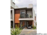 The image shows a modern two-story house with a modern design. The house has a combination of white and gray walls, with a la...