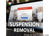 The image shows a laptop screen with the Google My Business website open. The website has a pop-up window with the text "Susp...