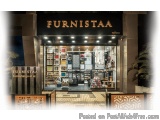 The image shows the entrance of a Furnistaa store. The store is located in a shopping mall with a modern design. The entrance...