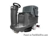 The image shows a floor scrubber dryer, which is a type of floor cleaning machine. It is a grey-colored machine with a black...