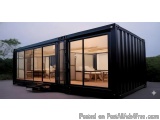 The image shows a black shipping container house with a modern design. The container is made of metal and has a sloping roof,...
