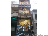 The image shows the entrance of a Royal Electricals store in India. The store is located on a street corner with a building o...