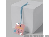 The image shows a white cube-shaped gift box with a blue ribbon tied around it. The ribbon is tied in a bow at the top and ha...
