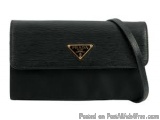 The image is of a black Prada clutch bag. The bag is made of a textured leather material and has a flap closure. On the front...