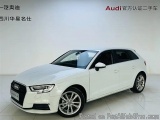 The image shows a white Audi car parked in a white room with a white floor and a white wall in the background. The car is a t...