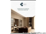 The image shows a modern and luxurious dressing room with a large wooden table in the center. The room has a high ceiling wit...