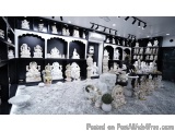 The image shows a room filled with various white statues and sculptures. The room has a black and white color scheme, with th...