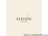The image is a logo for a salon called "Elevate Salon". The logo is written in black text on a light beige background. The te...