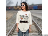 The image shows a young woman standing on a railway track. She is wearing a white t-shirt with the words "Timeless Classic" p...