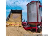 The image shows a large red and white Enochs grain silo with the word "Enochs" written on the side. The silo is located on a...