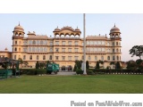 The image shows a large, ornate building with multiple levels and domes on top. The building appears to be a palace or a pala...