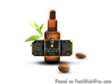The image shows a bottle of essential oil with a dropper on top. The bottle is made of amber glass and has a black label with...