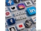 The image is a close-up of a keyboard with various social media icons scattered across it. The icons are arranged in a grid-l...