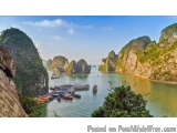 The image is a beautiful landscape of a mountainous area with a body of water in the foreground. The water is a deep blue-gre...