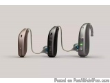 The image shows two hearing aids, one in black and one in silver. The hearing aids are connected by a cable, which is visible...