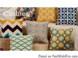 The image shows a collection of colorful throw pillows on a white couch. There are six pillows in total, each with a unique p...