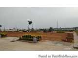 The image shows a barren landscape with a few buildings and trees in the background. The sky is overcast and the ground is co...