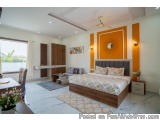 The image shows a modern and luxurious bedroom with a large bed in the center. The bed has a wooden headboard and footboard w...